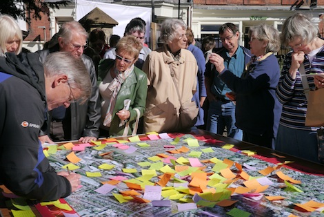 Visitors to the Vision Group's event place stickers on a map to record their concerns and priorities