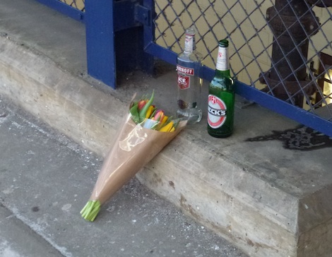 A single bunch of flowers left on platform 5, by empty bottles of vodka and beer, near the steps of the footbridge