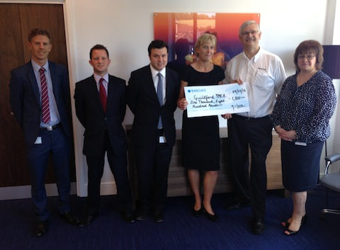 Guildford YMCA's CEO Pete Brayne (white shirt) receives the cheque from staff at Barclays Corporate, Guildford.