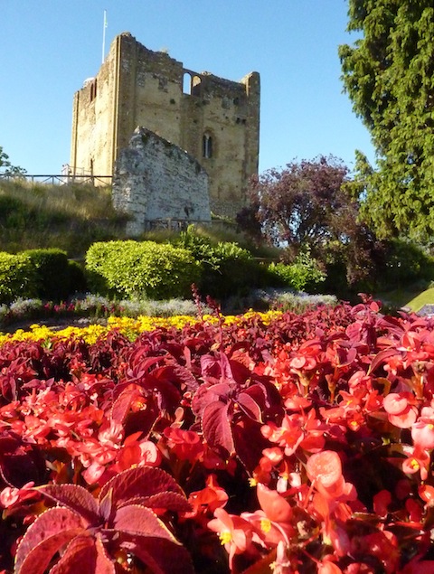 Vibrant reds contrast with the buff colours of the Great Tower and a pure blue sky.