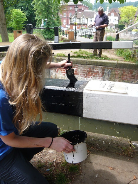 Helped by his daughter, Rob refreshes the paintwork on Millmead Lock