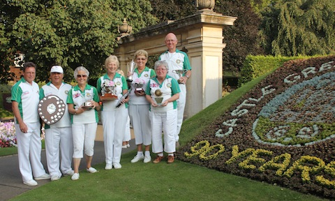 From left: Paul Plummer, Larry Webster, Jill Bird, Vivien Smith, , Shirley West, Julie Hinde and Colin Summerhayes standing beside the flower display celebrating Castle Green Bowling Club's 90th anniversary year.