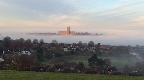 Guildford Cathedral illuminated by winter sunlight with a band of mist below.