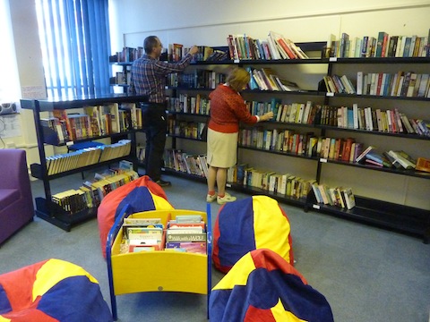Browsing some of the books at the community library hosted by Kings College.