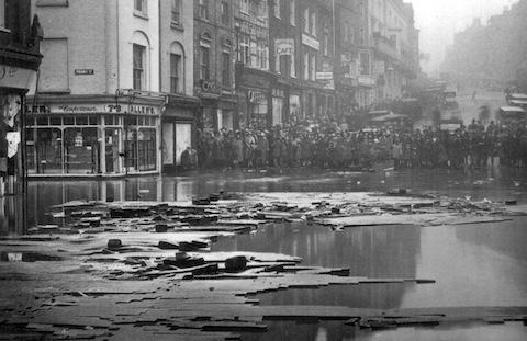 Crowds gather at the foot of the High Street to view the flodwaters. The timber in the foreground was most likely washed down from Moon's yard, now the site of Debenhams.