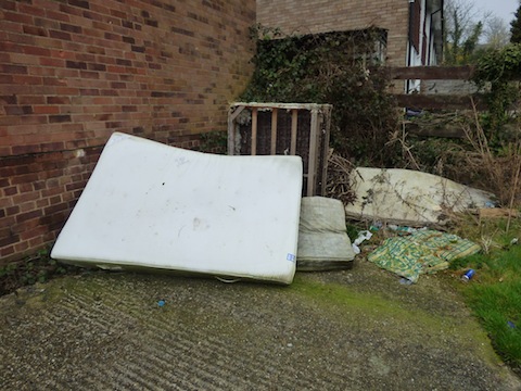 More fly-tipped rubbish, although by the garages it is also close to someone's home and garden.