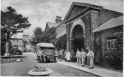 This building was used as a military hospital during the First World War. The unfortunate occupants were moved elsewhere to accommodate the soldiers, some are seen here. What was it and what did it become? The arch was pulled down in about 1965.