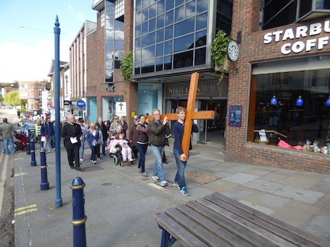 The Good Friday walk of witness makes it way up Guildford High Street.