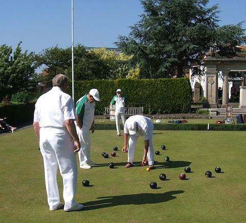 The photo shows the fine old art of measuring distance to see which team had its bowl or bowls closest to the jack.