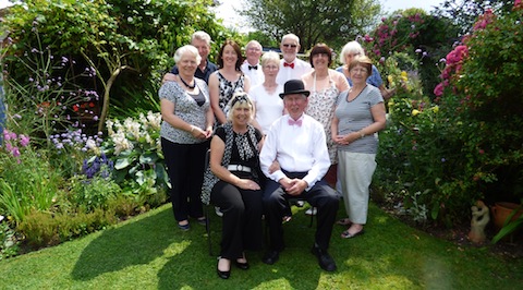 Sheila and Bob Willis (seated) with friends and relatives who helped make their vintage garden party a success.