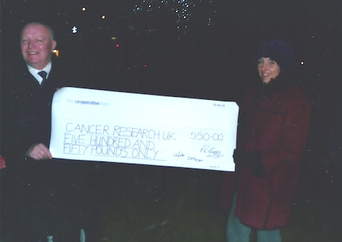Malcolm McNeil Charwynne, a representative of Cancer Research UK, receives the cheque from the clerk to Worplesdon Parish Council, Gaynor White,