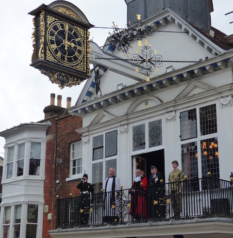The bugler plays Last Post on the balcony of the Guildhall. Also standing are the mayor, his chaplain and cadets.