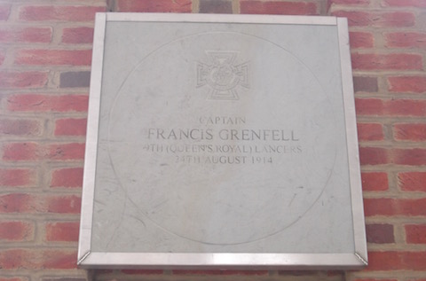 The stone memorial to Captain Francis Grenfell mounted on a wall in Tunsgate Arch. Note the rough and cheap looking metal frame that surrounds it.