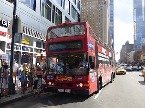 The Dennis bus parked in a famous part of Manhattan in New York City. Any ideas?