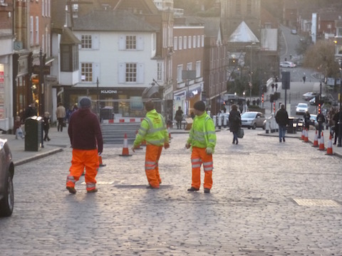 Workmen in Guildford High Street as repair and replacement of its granite setts is begun.
