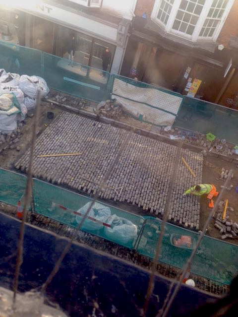 The granite setts in Guildford High Street being relaid, as seen from the first floor window of a shop.