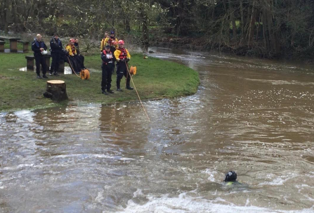 Police diver, attached by safety line, surfaces briefly during search of river bed at Millmead
