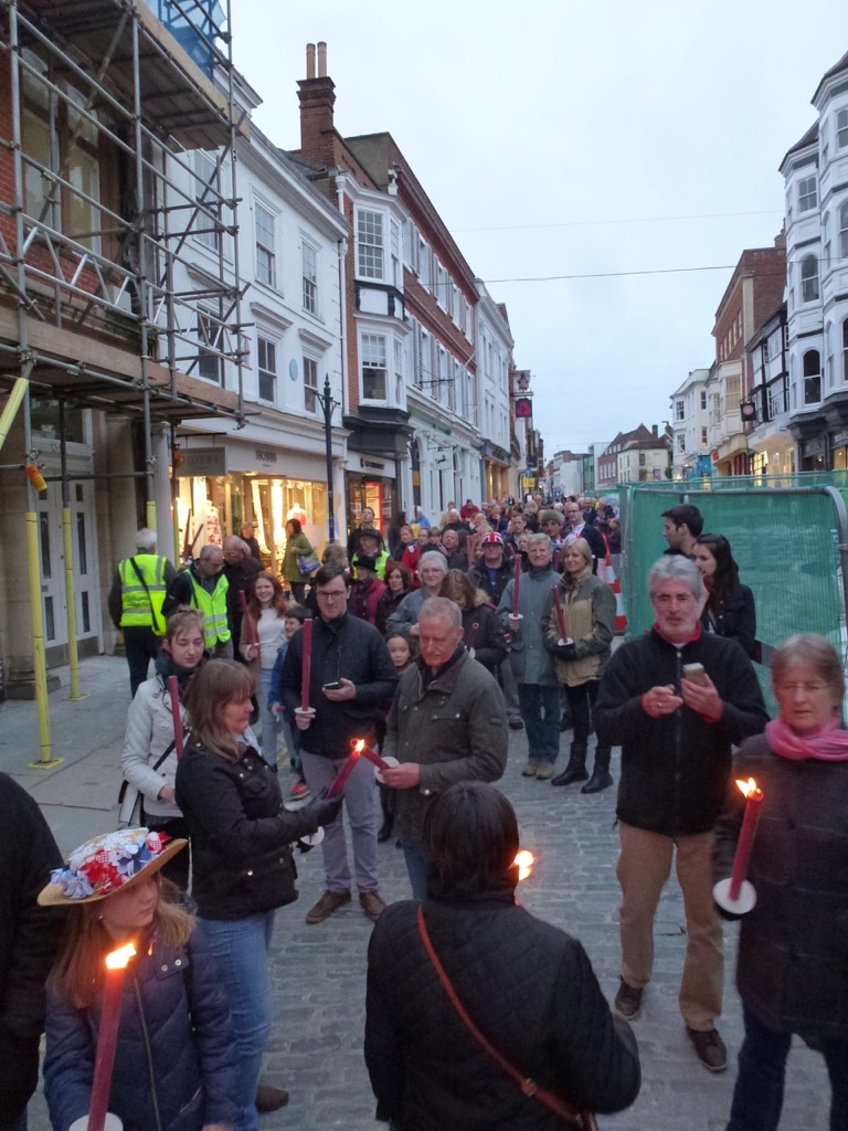 Guildfordians help each other to light up their torches at the start of the procession from the Guildhall to the Mount.