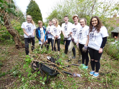 A team of young people make light work clearing an overgrown garden in Westborough.