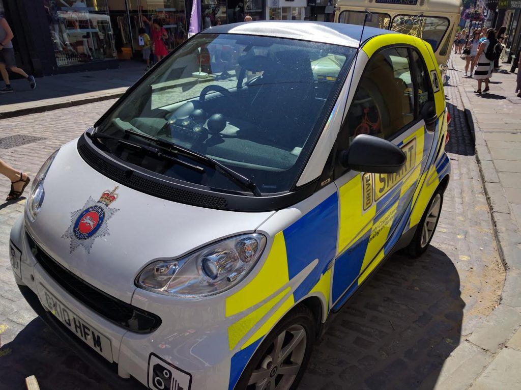 A modern imposter from Surrey Police. " A Smart car! I told you to choose a car that shows we mean crime busting business!"