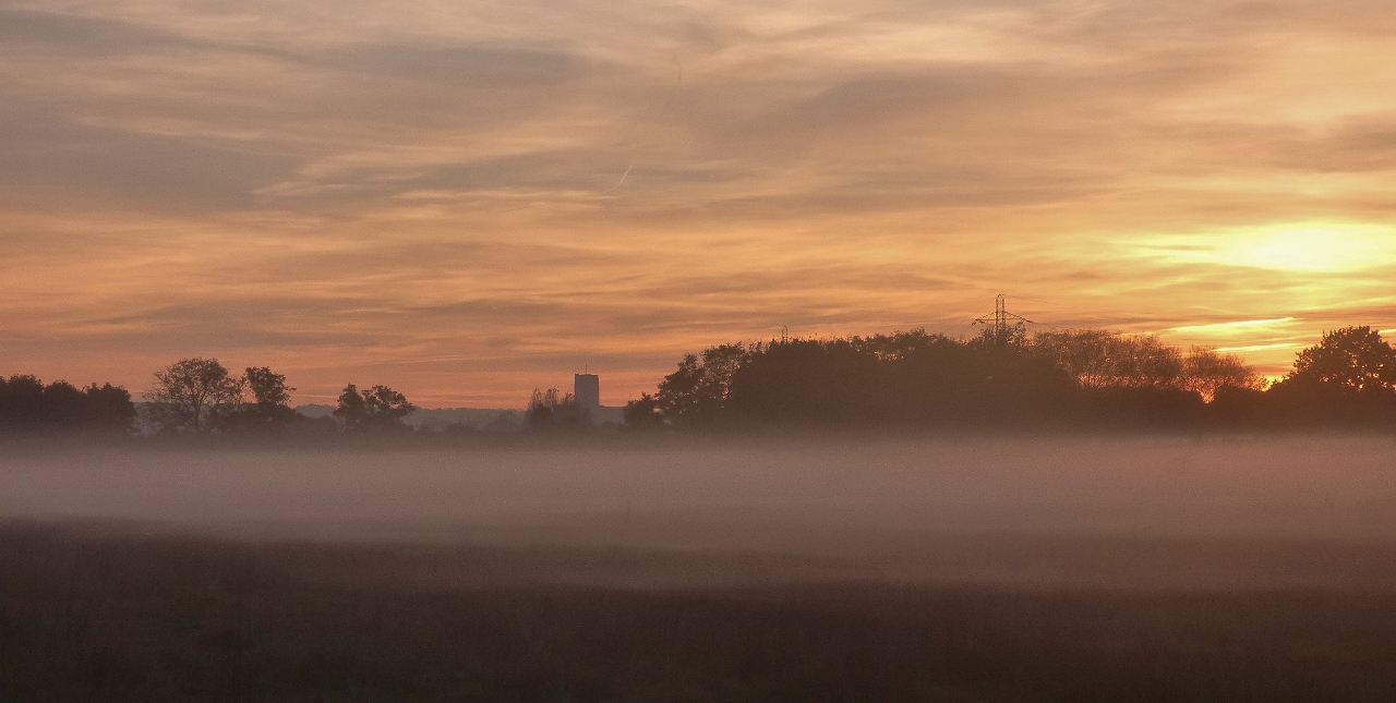Guildford Cathedral viewed as mist forms across the field at the southern end of Stoke Lake.