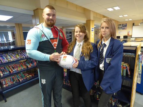 Harlequins rugby club's Cameron Holenstein signs a ball for Alex and Chel