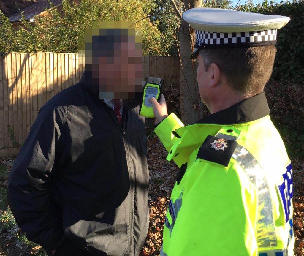 A Surrey police officer conducts a roadside breathalyser test